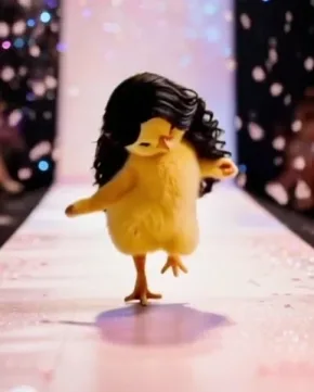 A fluffy yellow chick wearing a long black wig struts down a glittering runway.