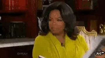 oprah-tell-me-more.gif Animated reaction GIF of Oprah Winfrey in a yellow top leaning forward with an eager, curious look, as if saying "tell me more."