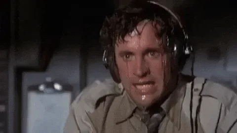 Nervous+Ted+Striker+GIF+by+filmeditor.gif A sweaty man wearing a headset wipes his forehead, looking distressed and tense.