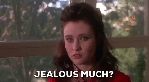 A young woman in a red vintage dress looks unimpressed and says 'Jealous much?'