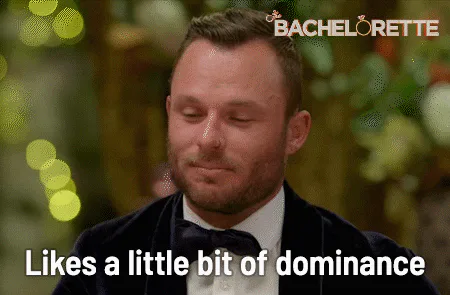 A man in a tuxedo closes his eyes and says 'Likes a little bit of dominance.'