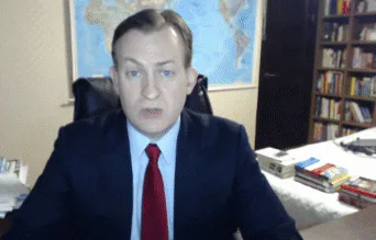 A man being interviewed on camera keeps his composure as two young children romp into the room behind him.