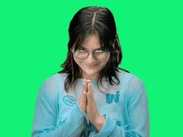 Planning+Plotting+GIF+by+Hulu+Friends.gif A woman with dark hair and glasses stands against a green screen, pressing her palms together in thanks.