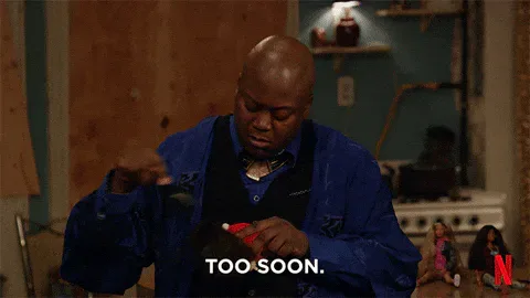 Tina+Fey+Titus+GIF+by+Unbreakable+Kimmy+Schmidt.gif A man holds a small object and says 'Too soon' in a wood-paneled room, with a Netflix logo shown.