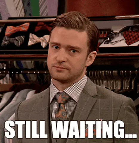 Justin+Timberlake+Waiting+GIF+by+MOODMAN.gif A man in a suit and tie looks unimpressed, captioned 'Still waiting...'
