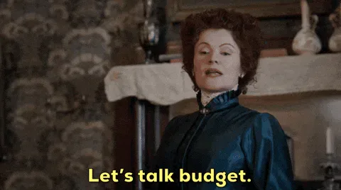 Rebecca+Wisocky+Money+GIF+by+CBS.gif A woman in a Victorian-style dress speaks as on-screen text reads 'Let's talk budget.'