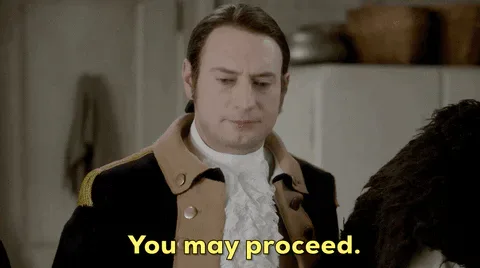 Go+On+Reaction+GIF+by+CBS.gif A man in an 18th century coat and ruffled collar says 'You may proceed.'