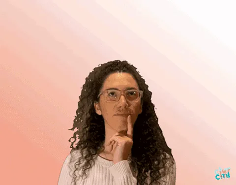 A woman taps her chin thoughtfully as a single cartoon lightbulb flickers on above her head.