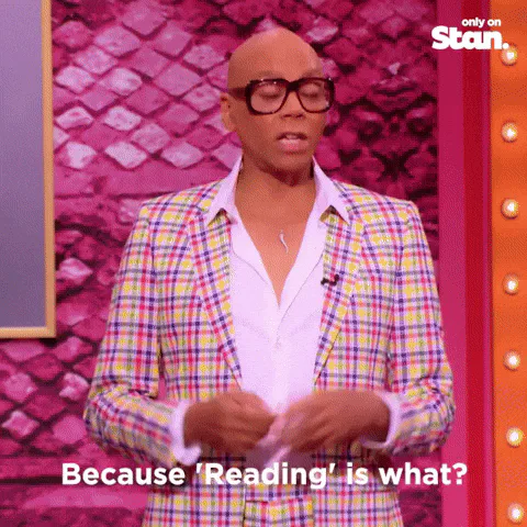 A bald man in glasses and a plaid suit asks 'Because Reading is what?' and a group answers 'Fundamental.'