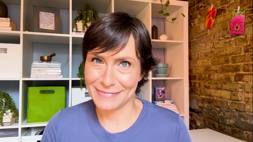 vlcsnap-2024-08-15-11h46m05s004.png A woman with short dark hair smiles at the camera in front of a bookshelf and an exposed brick wall.